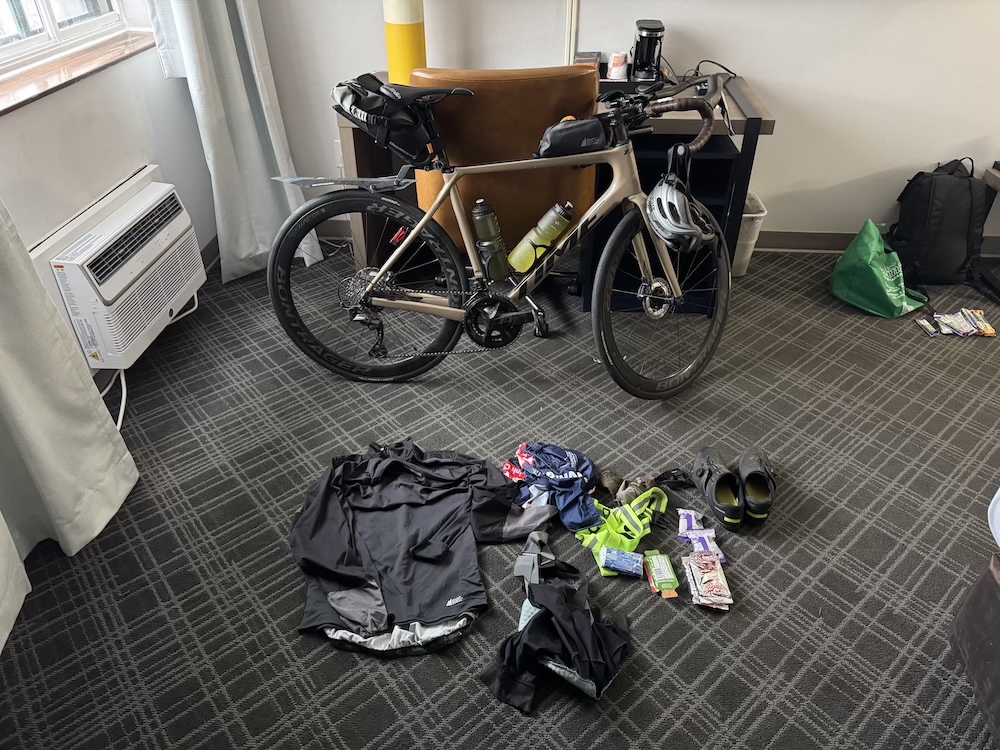 A Time ADHX 45 gravel bike in a hotel room with cycling kit and food laid out in front of it