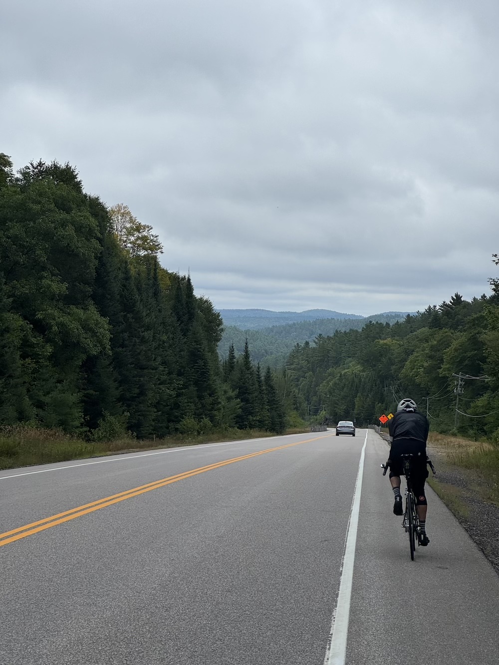 A cyclist begins a large downhill section in the scenic Canadian shield near Bancroft, Ontario.
